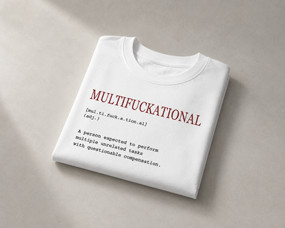 A folded white t-shirt with a humorous dictionary-style definition printed on the front, displayed on a neutral beige background.